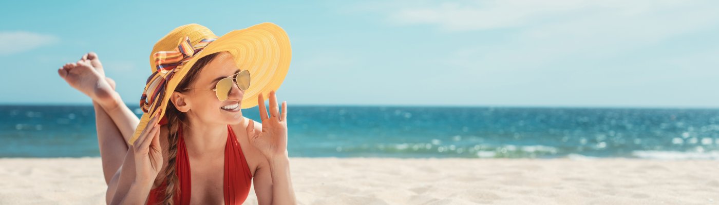 Woman enjoying her vacation by the sea tanning in the beach sand